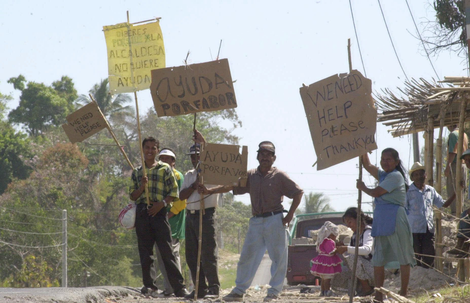 Victims of El Salvador’s second earthquake in 2001 stand with signs asking for help. Photo: AP